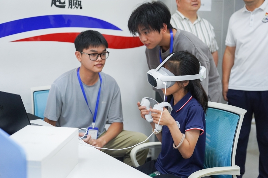 香港最新最准资料库信息工程学院学生正在指导研学团成员体验VR游戏。